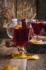 Christmas mulled wine with spices and oranges on wooden table, hot drinks