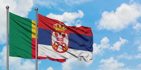 Benin and Serbia flag waving in the wind against white cloudy blue sky together. Diplomacy concept, international relations.