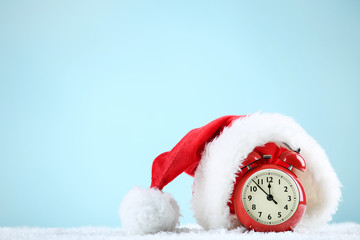Santa hat with red alarm clock on blue background