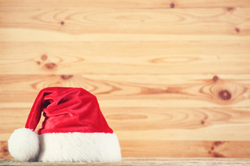 Obraz na płótnie Canvas Red santa hat on brown wooden background