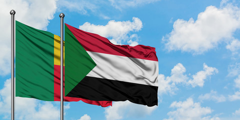 Benin and Sudan flag waving in the wind against white cloudy blue sky together. Diplomacy concept, international relations.