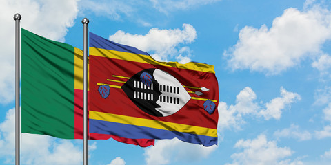 Benin and Swaziland flag waving in the wind against white cloudy blue sky together. Diplomacy concept, international relations.
