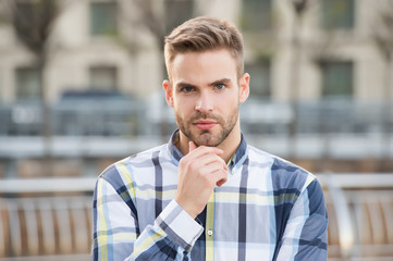 Obraz premium Trim or shave. Unshaven guy touch beard hair outdoor. Handsome man wear beard. Bearded man with stylish mustache and beard shape. Mens grooming salon. Beard grooming. Barbershop