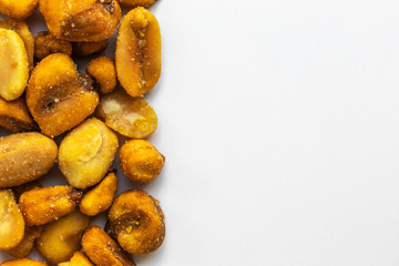 A mixture of peanuts, hazelnuts, pistachios, almonds with spices and sweet mustard are located on a white background in the left part of the image, on the right is an empty place