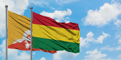 Bhutan and Bolivia flag waving in the wind against white cloudy blue sky together. Diplomacy concept, international relations.