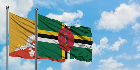 Bhutan and Dominica flag waving in the wind against white cloudy blue sky together. Diplomacy concept, international relations.