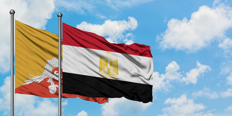 Bhutan and Egypt flag waving in the wind against white cloudy blue sky together. Diplomacy concept, international relations.
