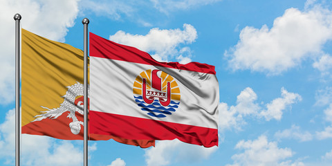 Bhutan and French Polynesia flag waving in the wind against white cloudy blue sky together. Diplomacy concept, international relations.