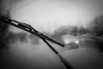 car windshield wipers in rainy season, black and white photo with vignetting, front and rear background blurred with bokeh effect - obrazy, fototapety, plakaty
