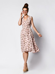 Full length portrait of happy beautiful woman in pink dress posing in studio isolated on white...