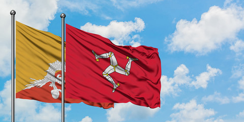 Bhutan and Isle Of Man flag waving in the wind against white cloudy blue sky together. Diplomacy concept, international relations.