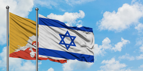 Bhutan and Israel flag waving in the wind against white cloudy blue sky together. Diplomacy concept, international relations.