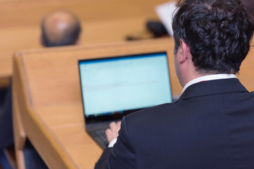 Businessman at business conference room with public giving presentations. Audience at the...