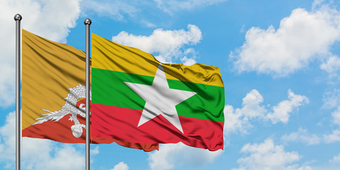 Bhutan and Myanmar flag waving in the wind against white cloudy blue sky together. Diplomacy concept, international relations.