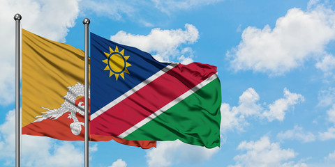 Bhutan and Namibia flag waving in the wind against white cloudy blue sky together. Diplomacy concept, international relations.
