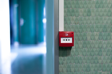 Fire alarm button on a green wall