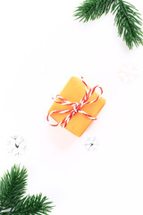 Christmas holiday composition Orange gift box with fir branches on a white background. minimalistic holiday concept
