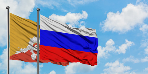Bhutan and Russia flag waving in the wind against white cloudy blue sky together. Diplomacy concept, international relations.