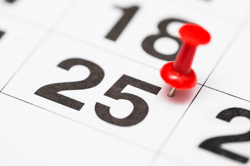 Pin on the date number 25. The twenty fifth day of the month is marked with a red thumbtack. Pin on calendar