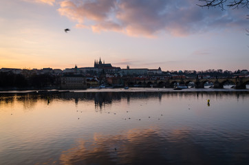 Reflections of the city on the Moldava river at sunset, Prague, Czech Republic