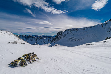 Beautiful winter alpine mountain landscape of Niedere Tauern. Alpine landscape covered with snow, high alpine peaks near Hohetauern ski resort, Austria. Mountains in winter, blue sky, ski touring.
