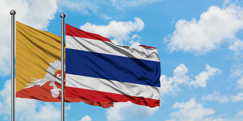 Bhutan and Thailand flag waving in the wind against white cloudy blue sky together. Diplomacy concept, international relations.