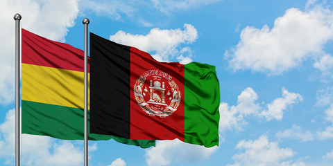 Bolivia and Afghanistan flag waving in the wind against white cloudy blue sky together. Diplomacy concept, international relations.