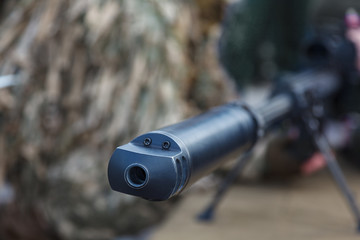 Soldier in special camouflage suit with sniper rifle. Camouflage hunter aiming with his rifle ....