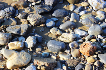 Sea stones and rocks on the beach of different sizes and textures Seamless stone texture background.