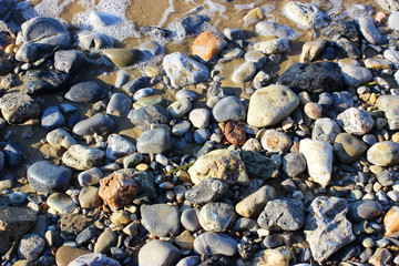 Sea stones and rocks on the beach of different sizes and textures Seamless stone texture background.
