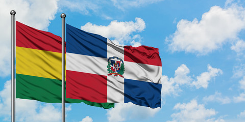 Bolivia and Dominican Republic flag waving in the wind against white cloudy blue sky together. Diplomacy concept, international relations.