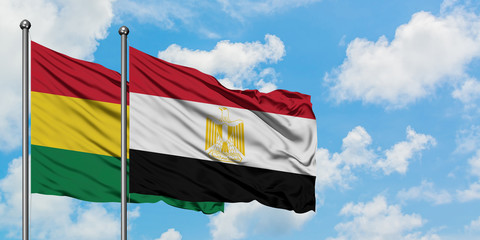 Bolivia and Egypt flag waving in the wind against white cloudy blue sky together. Diplomacy concept, international relations.