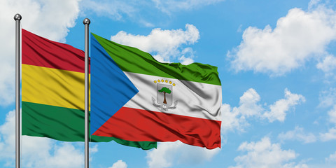 Bolivia and Equatorial Guinea flag waving in the wind against white cloudy blue sky together. Diplomacy concept, international relations.