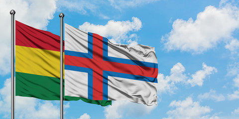 Bolivia and Faroe Islands flag waving in the wind against white cloudy blue sky together. Diplomacy concept, international relations.