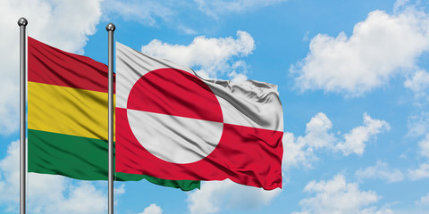 Bolivia and Greenland flag waving in the wind against white cloudy blue sky together. Diplomacy concept, international relations.