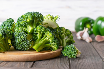Fresh cut green broccoli on wooden kitchen table. Vegetarian ingredients