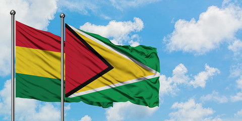 Bolivia and Guyana flag waving in the wind against white cloudy blue sky together. Diplomacy concept, international relations.