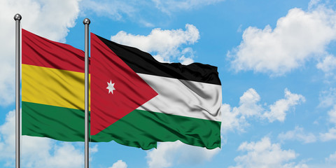Bolivia and Jordan flag waving in the wind against white cloudy blue sky together. Diplomacy concept, international relations.