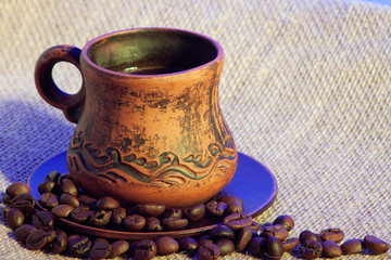 Mug of coffee on burlap. Blue shadow