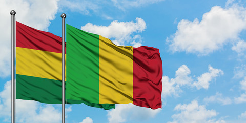 Bolivia and Mali flag waving in the wind against white cloudy blue sky together. Diplomacy concept, international relations.