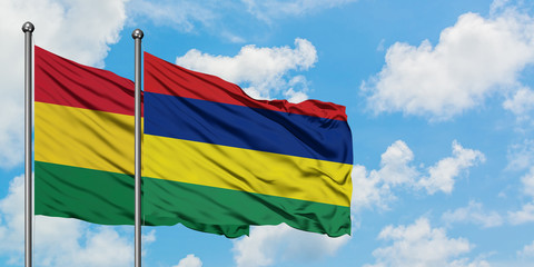Bolivia and Mauritius flag waving in the wind against white cloudy blue sky together. Diplomacy concept, international relations.