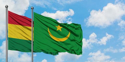 Bolivia and Mauritania flag waving in the wind against white cloudy blue sky together. Diplomacy concept, international relations.