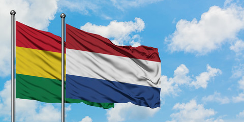 Bolivia and Netherlands flag waving in the wind against white cloudy blue sky together. Diplomacy concept, international relations.
