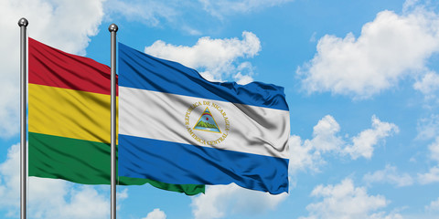 Bolivia and Nicaragua flag waving in the wind against white cloudy blue sky together. Diplomacy concept, international relations.