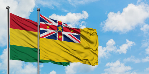 Bolivia and Niue flag waving in the wind against white cloudy blue sky together. Diplomacy concept, international relations.