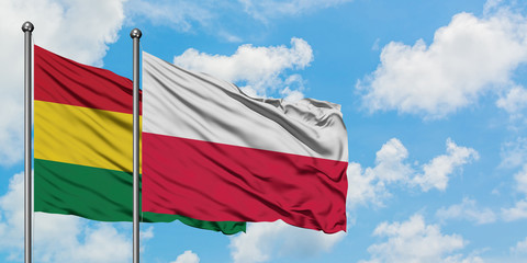 Bolivia and Poland flag waving in the wind against white cloudy blue sky together. Diplomacy concept, international relations.