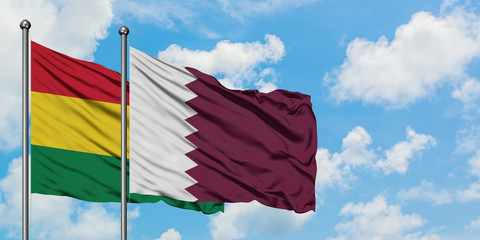 Bolivia and Qatar flag waving in the wind against white cloudy blue sky together. Diplomacy concept, international relations.