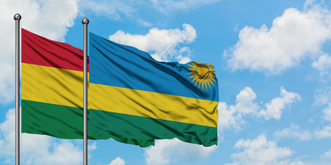 Bolivia and Rwanda flag waving in the wind against white cloudy blue sky together. Diplomacy concept, international relations.