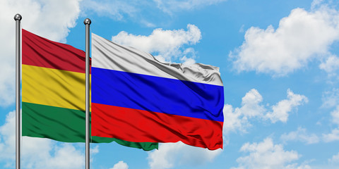 Bolivia and Russia flag waving in the wind against white cloudy blue sky together. Diplomacy concept, international relations.