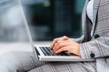 Close-up of businesswoman using laptop outdoors